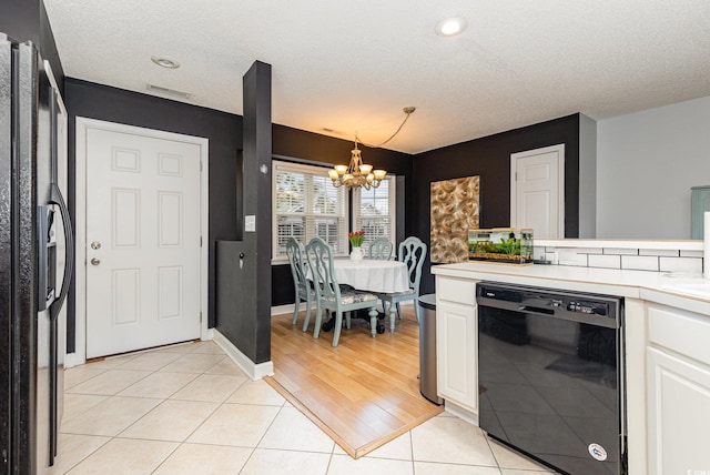 kitchen with a notable chandelier, light countertops, light tile patterned flooring, white cabinetry, and black appliances