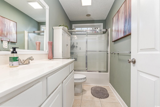 bathroom with toilet, tile patterned flooring, combined bath / shower with glass door, a textured ceiling, and vanity