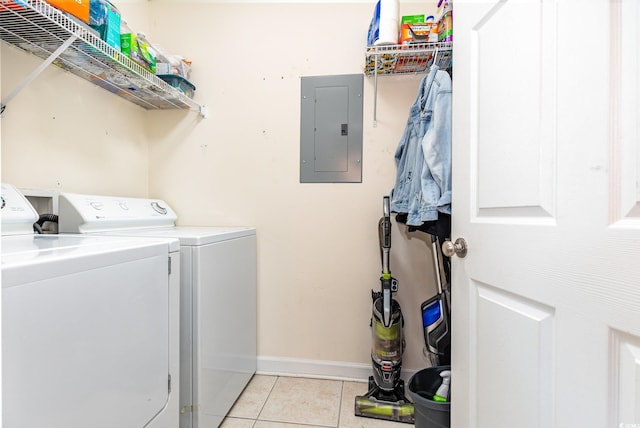 clothes washing area featuring light tile patterned floors, laundry area, baseboards, washer and dryer, and electric panel