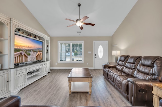 living area featuring light wood finished floors, ceiling fan, and vaulted ceiling