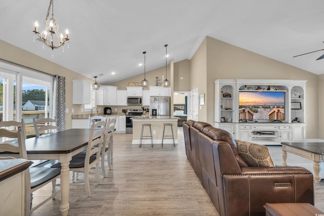 interior space featuring recessed lighting, ceiling fan with notable chandelier, light wood-type flooring, and high vaulted ceiling