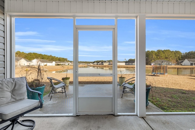 sunroom / solarium featuring a water view