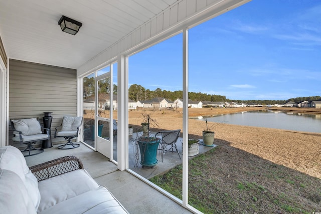 sunroom / solarium featuring a water view