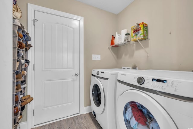 washroom with light wood-type flooring, laundry area, and washer and clothes dryer