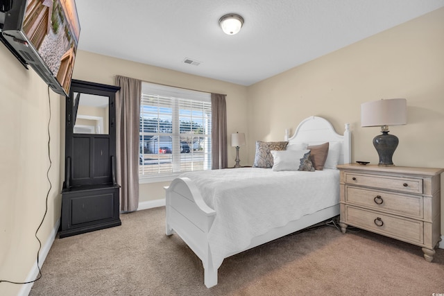 bedroom featuring light colored carpet, visible vents, and baseboards