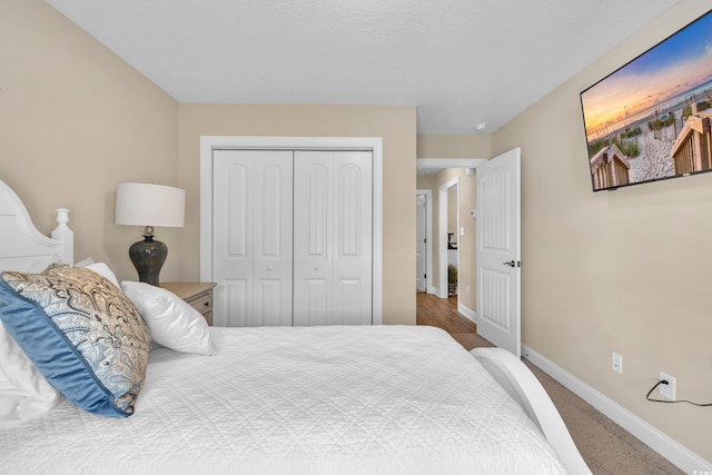 bedroom with carpet flooring, baseboards, and a closet