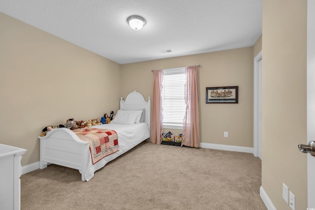 carpeted bedroom featuring visible vents, baseboards, and a textured ceiling