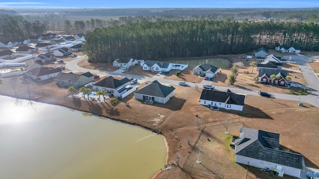 aerial view with a wooded view, a water view, and a residential view