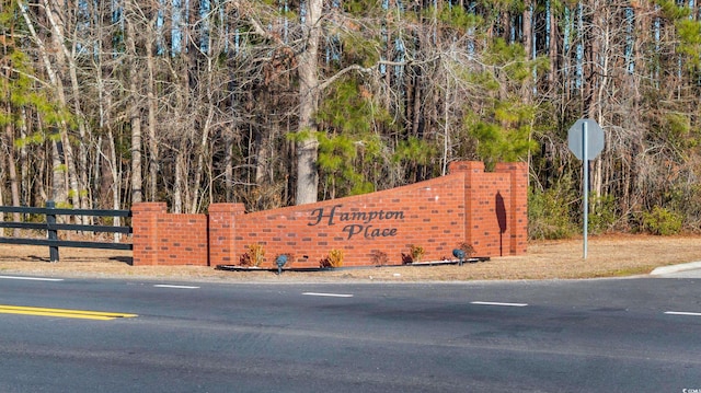 community / neighborhood sign with fence