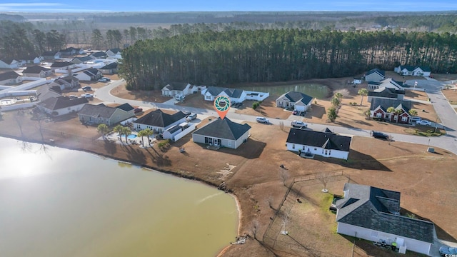 drone / aerial view featuring a residential view, a forest view, and a water view