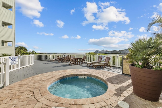 view of swimming pool featuring a community hot tub and a deck