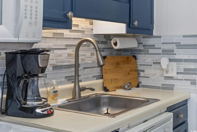 kitchen with blue cabinetry, sink, and backsplash