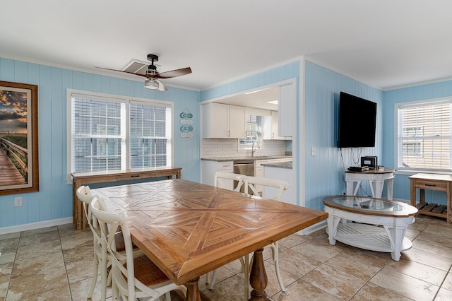 dining room featuring crown molding, sink, and ceiling fan