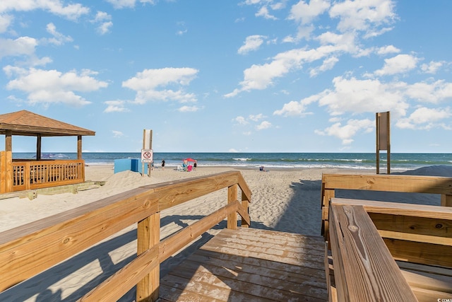 view of property's community with a view of the beach, a gazebo, and a water view