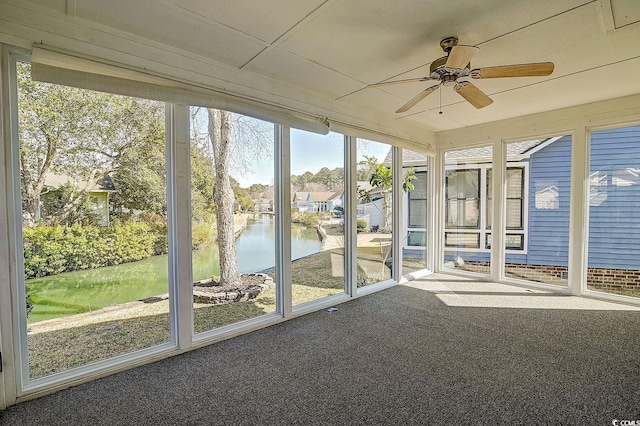 unfurnished sunroom featuring a water view and ceiling fan