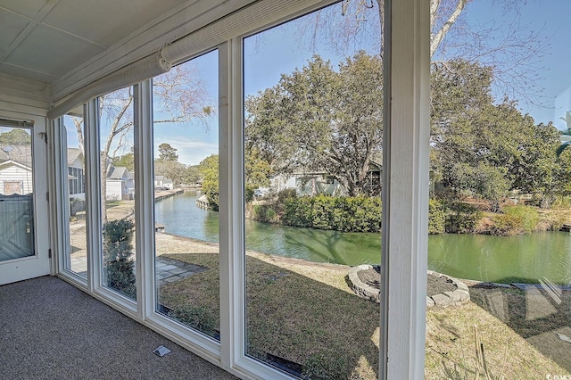 doorway to outside with carpet flooring and a water view