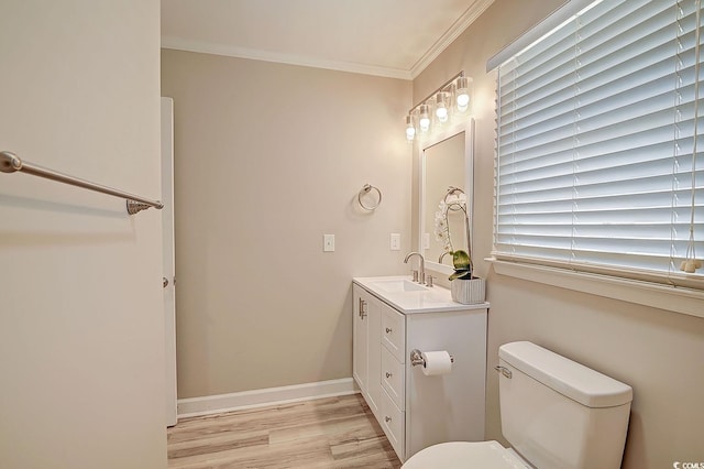 bathroom with ornamental molding, hardwood / wood-style floors, vanity, and toilet