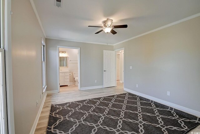 unfurnished bedroom with ceiling fan, ornamental molding, wood-type flooring, and ensuite bathroom