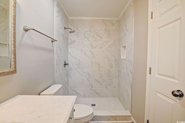 bathroom featuring tiled shower, vanity, toilet, and ornamental molding