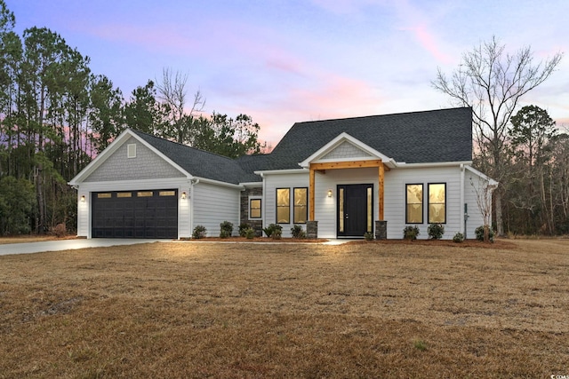 view of front of house featuring a garage and a lawn