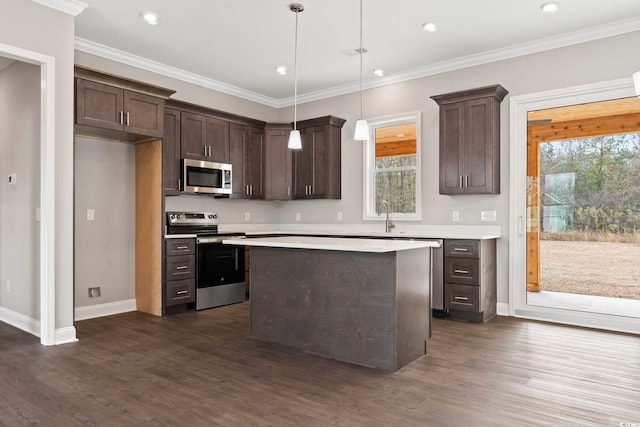 kitchen with appliances with stainless steel finishes, dark wood-type flooring, hanging light fixtures, and a center island