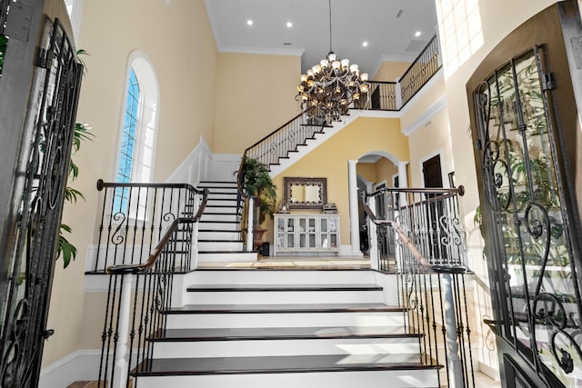 interior space with ornamental molding, a chandelier, and a high ceiling