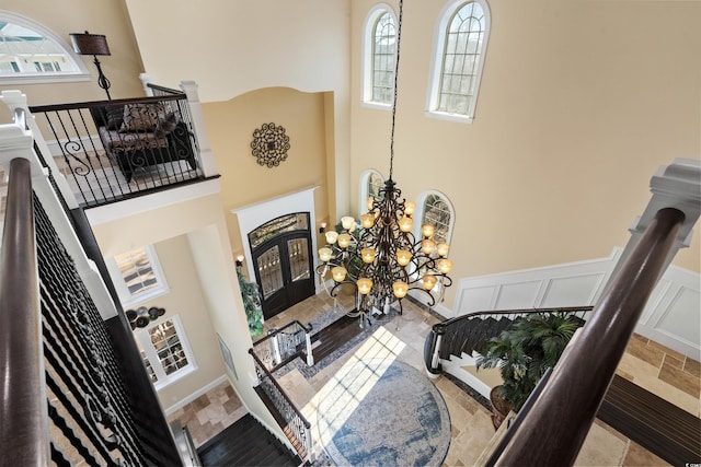 living room featuring a notable chandelier, a towering ceiling, and a wealth of natural light