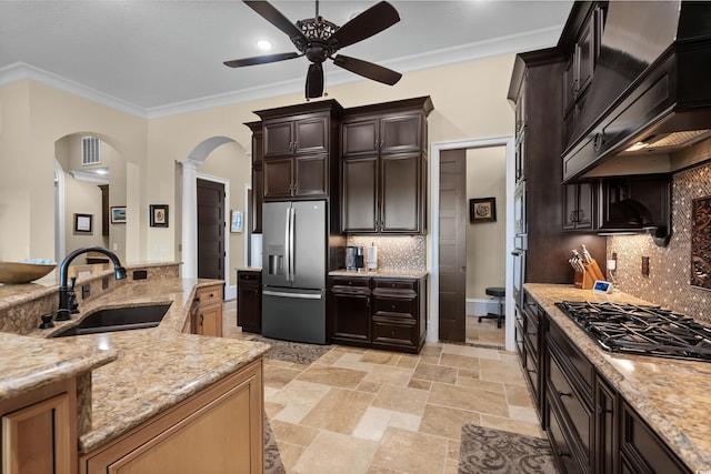 kitchen with sink, crown molding, premium range hood, appliances with stainless steel finishes, and backsplash