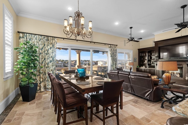 dining space with ornamental molding and ceiling fan with notable chandelier