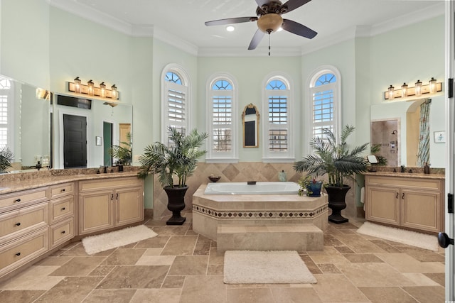 bathroom featuring crown molding, plenty of natural light, a relaxing tiled tub, and vanity