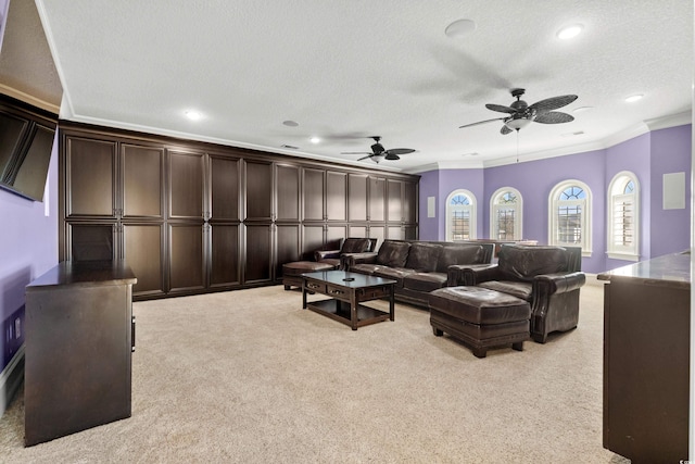 living room featuring ornamental molding, light carpet, ceiling fan, and a textured ceiling