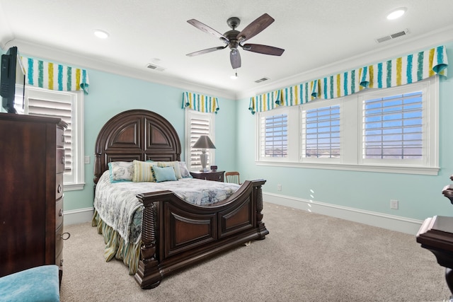 carpeted bedroom featuring crown molding and ceiling fan