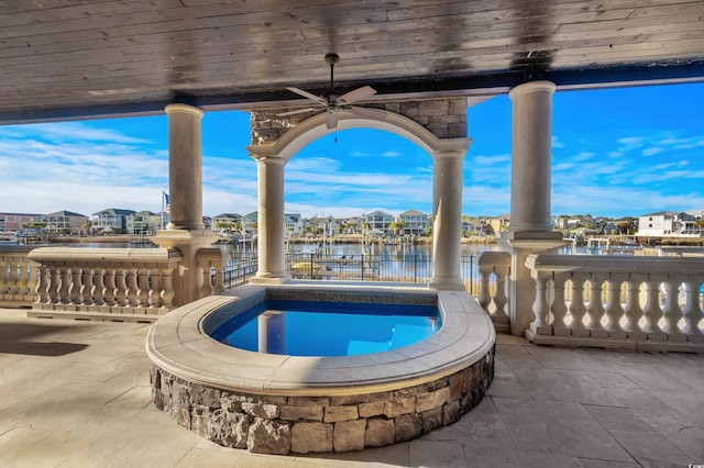 view of pool featuring a patio area, an in ground hot tub, ceiling fan, and a water view