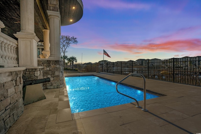 pool at dusk with a patio