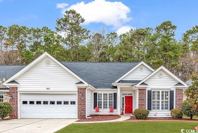 view of front facade with a front lawn, brick siding, driveway, and an attached garage