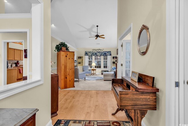 interior space featuring lofted ceiling, crown molding, and light wood-type flooring