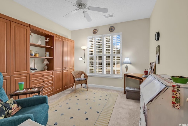 sitting room with visible vents, a ceiling fan, light carpet, a textured ceiling, and baseboards