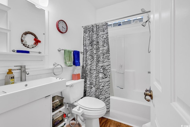 bathroom featuring a sink, shower / tub combo with curtain, toilet, and wood finished floors