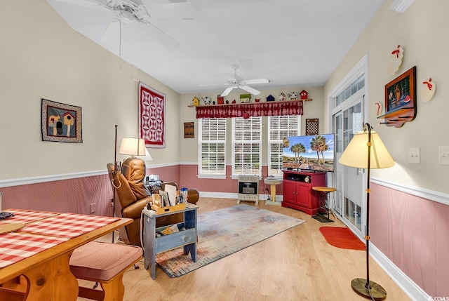 rec room featuring a ceiling fan, light wood-type flooring, wainscoting, and heating unit