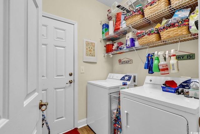 laundry area featuring laundry area, baseboards, washer and dryer, and wood finished floors