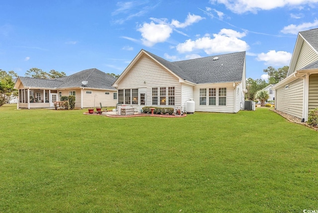 back of property with a sunroom, a patio area, a yard, and central air condition unit