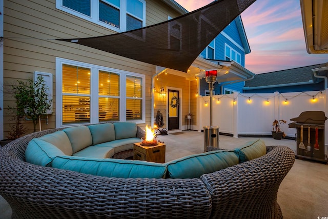 patio terrace at dusk featuring a grill and an outdoor living space with a fire pit