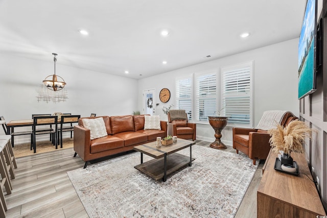 living room featuring an inviting chandelier and light hardwood / wood-style floors