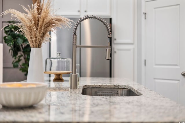 details featuring light stone countertops and white cabinets