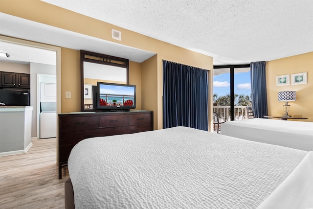 2700 N Ocean Blvd Unit 253, Myrtle Beach, SC 29577 - bedroom with estacked washer and dryer, fridge, a textured ceiling, access to outside, and light wood finished floors