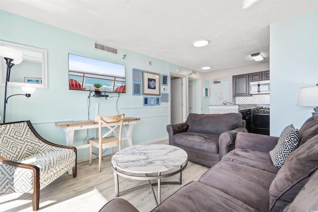 2700 N Ocean Blvd Unit 253, Myrtle Beach, SC 29577 - living room featuring light wood-type flooring, a textured ceiling, and baseboards