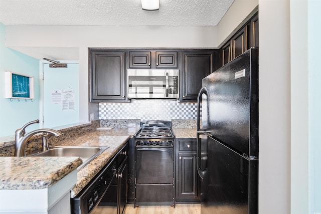 2700 N Ocean Blvd Unit 253, Myrtle Beach, SC 29577 - kitchen featuring black appliances, a sink, a peninsula, a textured ceiling, and backsplash
