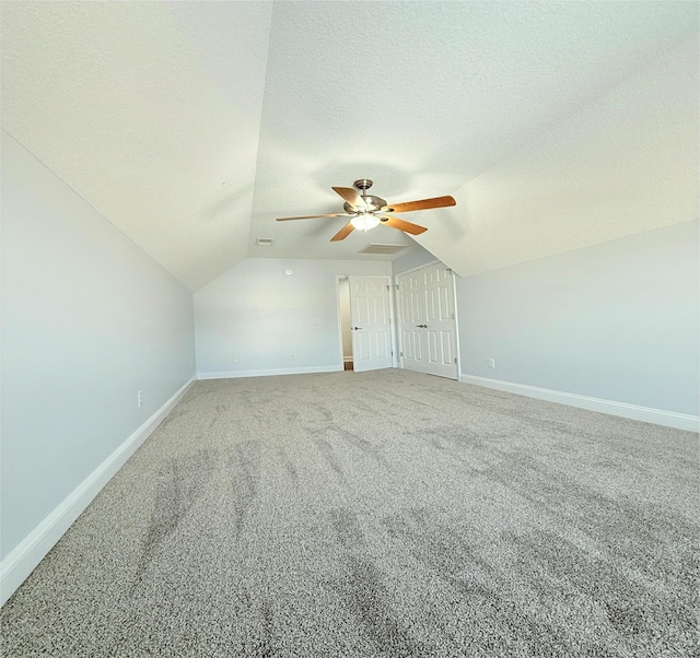 additional living space featuring lofted ceiling, ceiling fan, carpet floors, and a textured ceiling