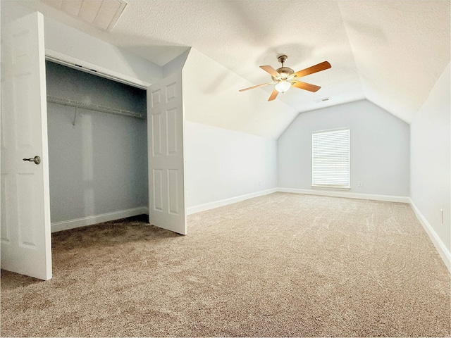 bonus room featuring vaulted ceiling, ceiling fan, carpet floors, and a textured ceiling