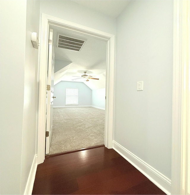 hall with lofted ceiling and dark hardwood / wood-style flooring